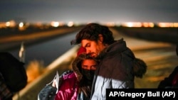 Una pareja de Cuba espera ser procesada para solicitar asilo después de cruzar la frontera cerca de Yuma, Arizona. (AP/Gregory Bull)