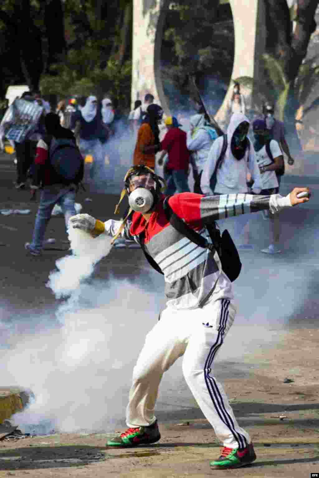 Un grupo de manifestantes se defienden de la policía durante una protesta