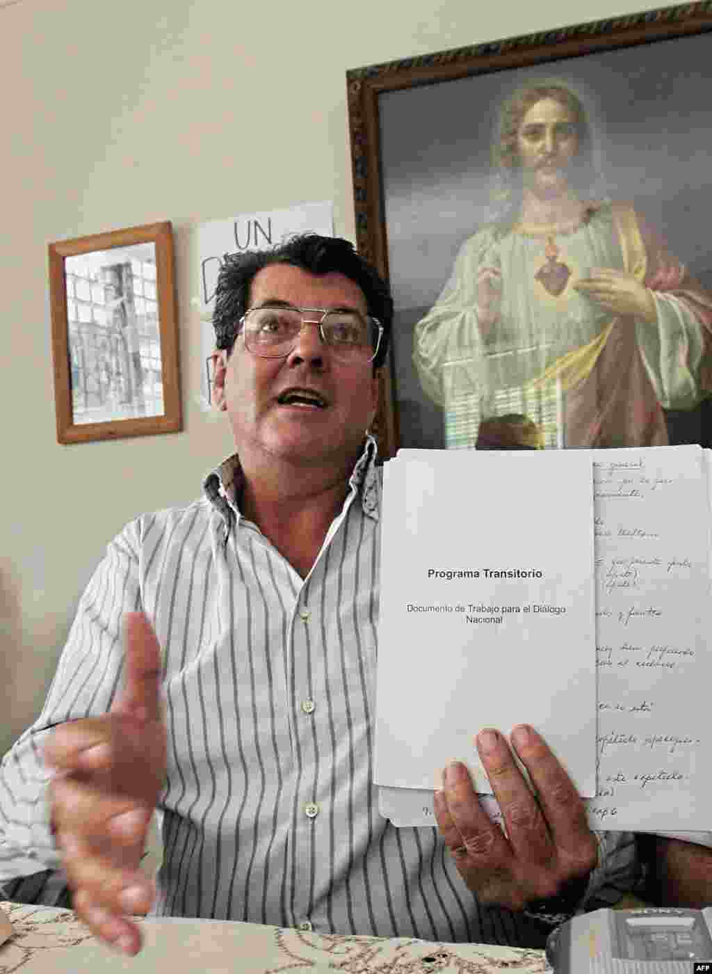 Oswaldo Payá muestra el documento temporal de un programa tentativo para un diálogo nacional durante una conferencia de prensa en su casa, en La Habana, el 17 de febrero de 2005.