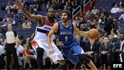 El jugador de Timberwolves Ricky Rubio (d) es marcado por Nene Hilario (i), de Wizards, durante un partido por la NBA, en el Verizon Center de Washington (DC, EE.UU.). 