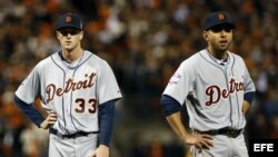 Jugadores de los Tigres de Detroit Drew Smyly (i) y Omar Infante observan una pase intencional al bateador de Pablo Sandoval de los Gigantes de San Francisco. 