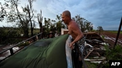 Hombres cargan un colchón dañado en un camión después del paso del huracán Rafael en Alquízar, provincia de Artemisa, Cuba, el 7 de noviembre de 2024. (Yamil Lage/AFP)