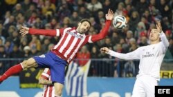 El jugador del Atlético de Madrid Juanfran Torres disputa el balón con Cristiano Ronaldo