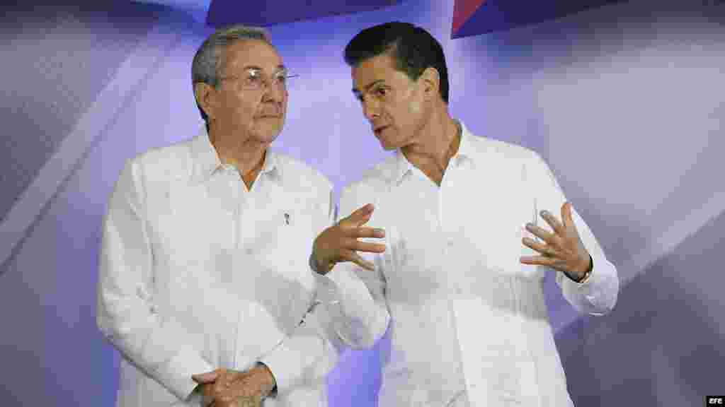 El presidente de México Enrique Peña Nieto conversa con el gobernante cubano Raúl Castro (d-i), durante una rueda de prensa conjunta en Palacio de Gobierno del estado de Yucatán.